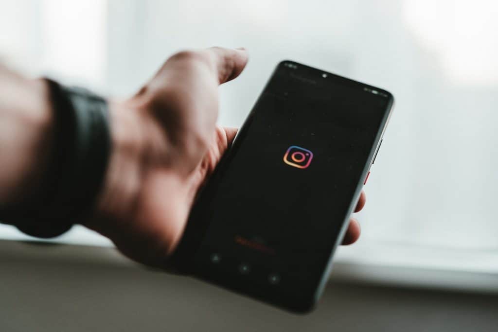 Man holding phone with Instagram logo